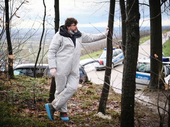 Schauspieler Hans-Jochen Wagner steht Dreharbeiten zum Schwarzwald-Tatort "Das Geständnis" in einem weißen Schutzanzug im Wald.