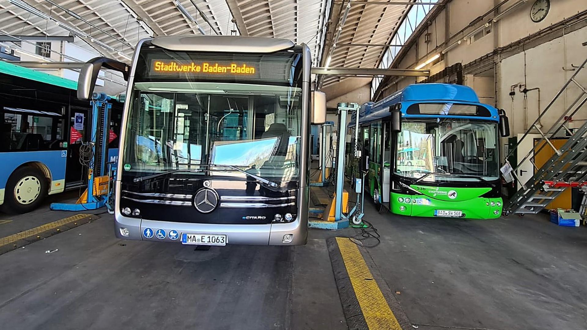 Zwei Busse stehen in einer großen Wagenhalle. 