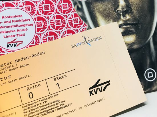 Eine Hand hält eine Eintrittskarte für das Theater Baden-Baden, die auch als Fahrkarte im öffentlichen Personennahverkehr gilt. 
