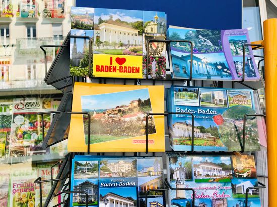 In einem Ständer liegen Postkarten mit Motiven von Baden-Baden.