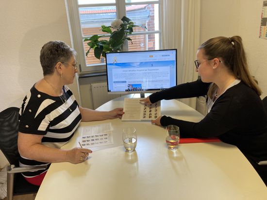 Zwei Frauen an einem Schreibtisch mit Bildschirm