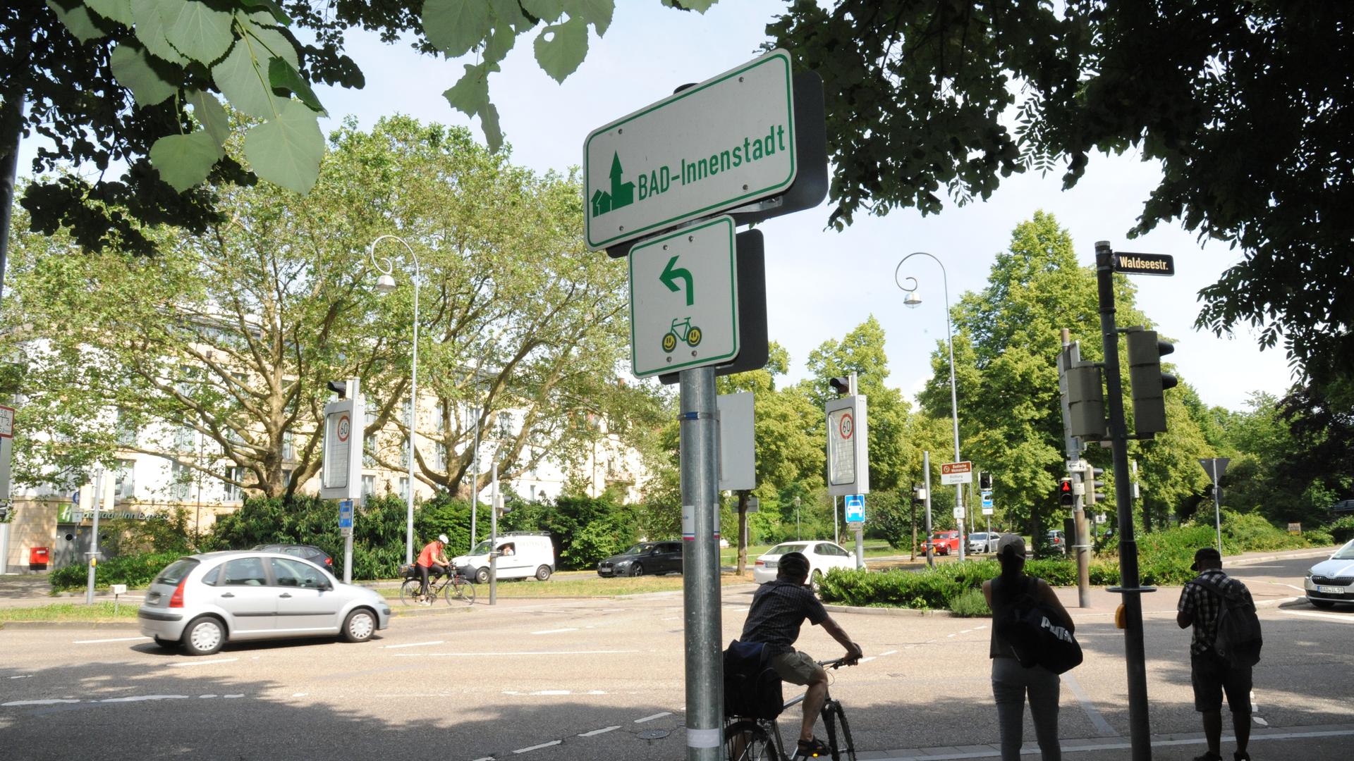 Radfahrer und Fußgänger warten an einer Ampel am Verfassungsplatz in Baden-Baden.