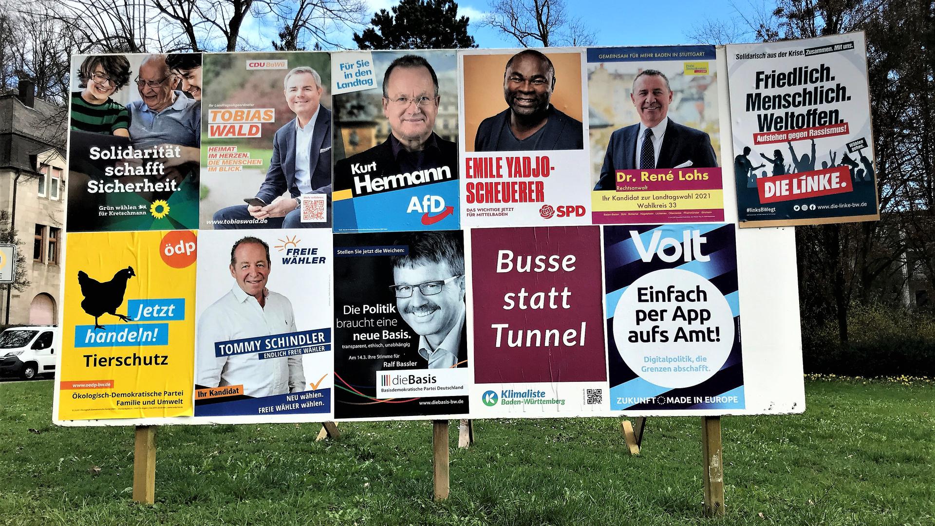 Eine große Wahlplakatwand zeigt die Kandidaten und Gruppierungen, die bei der Landtagswahl im Wahlkreis Baden-Baden antreten