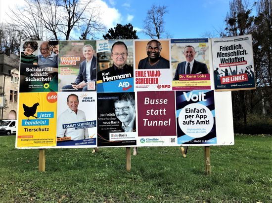 Eine große Wahlplakatwand zeigt die Kandidaten und Gruppierungen, die bei der Landtagswahl im Wahlkreis Baden-Baden antreten