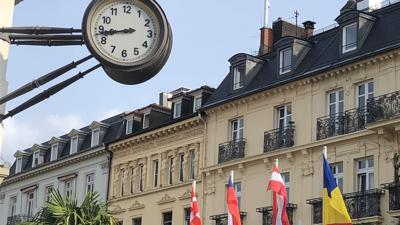 An einer Hausecke am Leopoldsplatz hängt eine gusseiserne Wanduhr