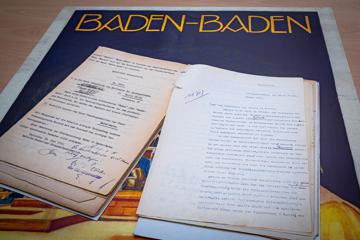 Der Antrag der Stadt Baden-Baden auf die Namensänderung von 1931 liegt auf einem Plakat, auf dem der Doppelname schon steht.