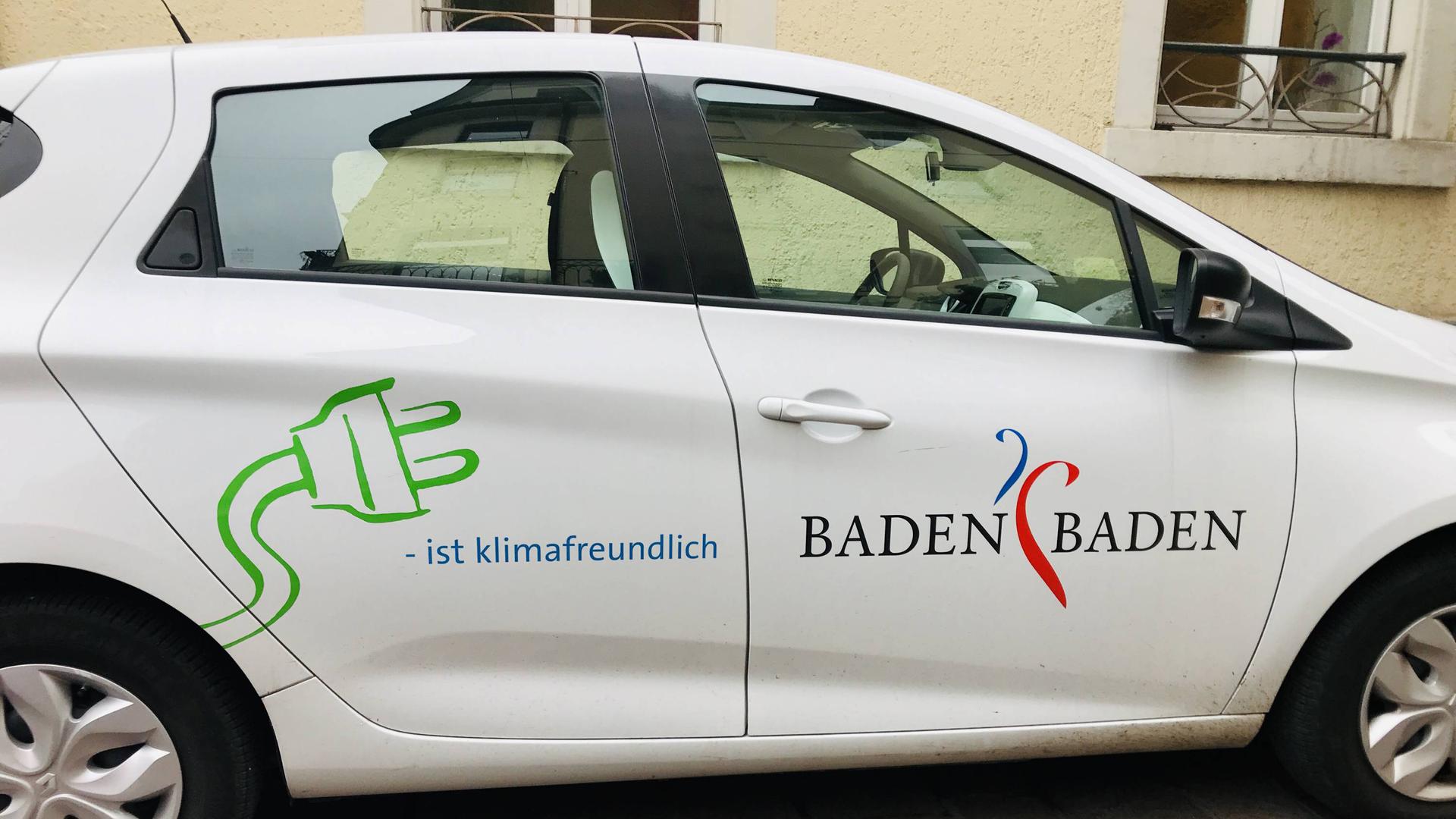 Ein weißer Pkw der Stadtverwaltung steht auf einem Parkplatz. Das E-Auto trägt die Aufschrift Baden-Baden und den Hinweis auf den Elektroantrieb
