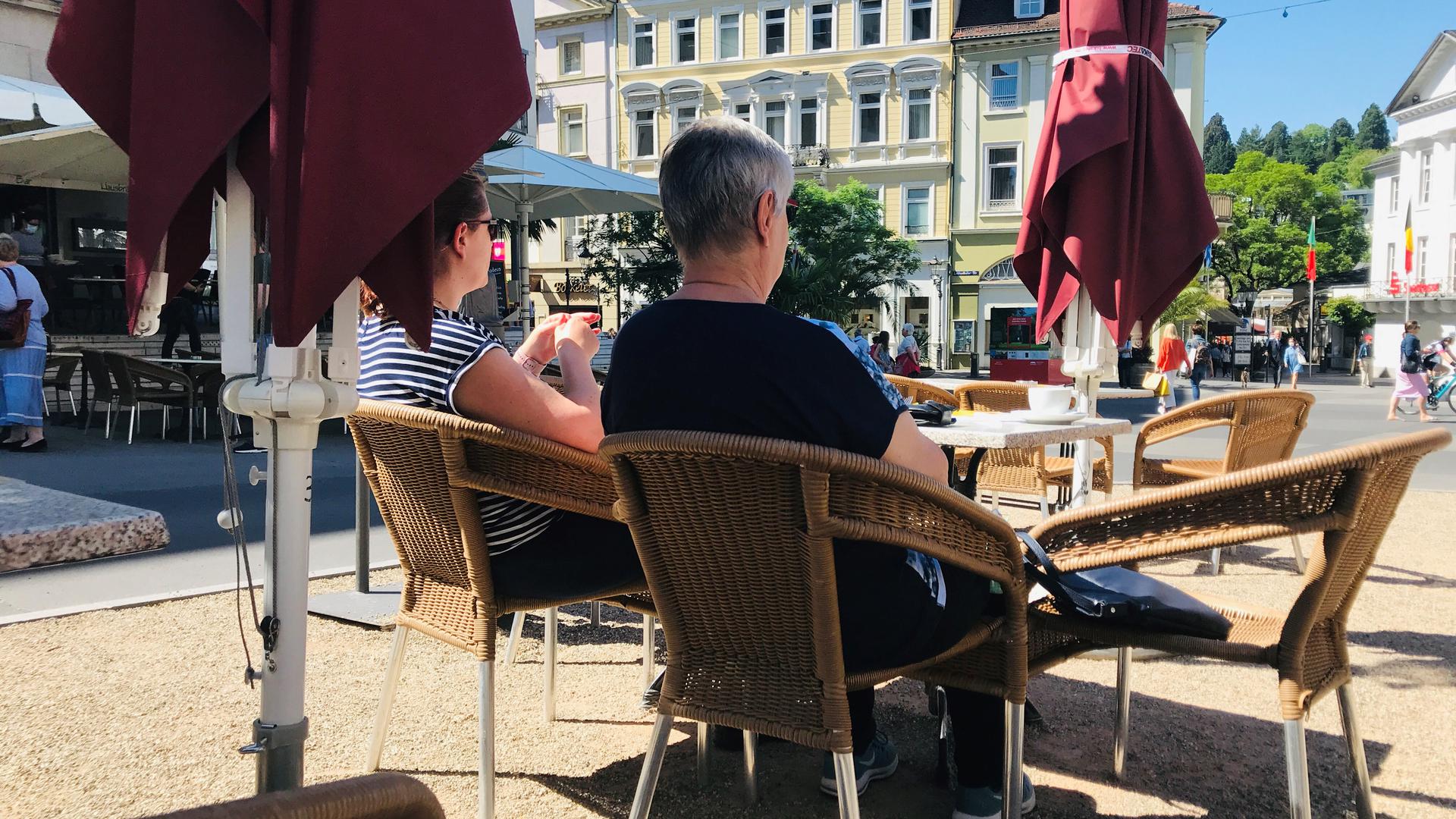 Zwei Frauen sitzen im Außenbereich eines Restaurants in Baden-Baden.