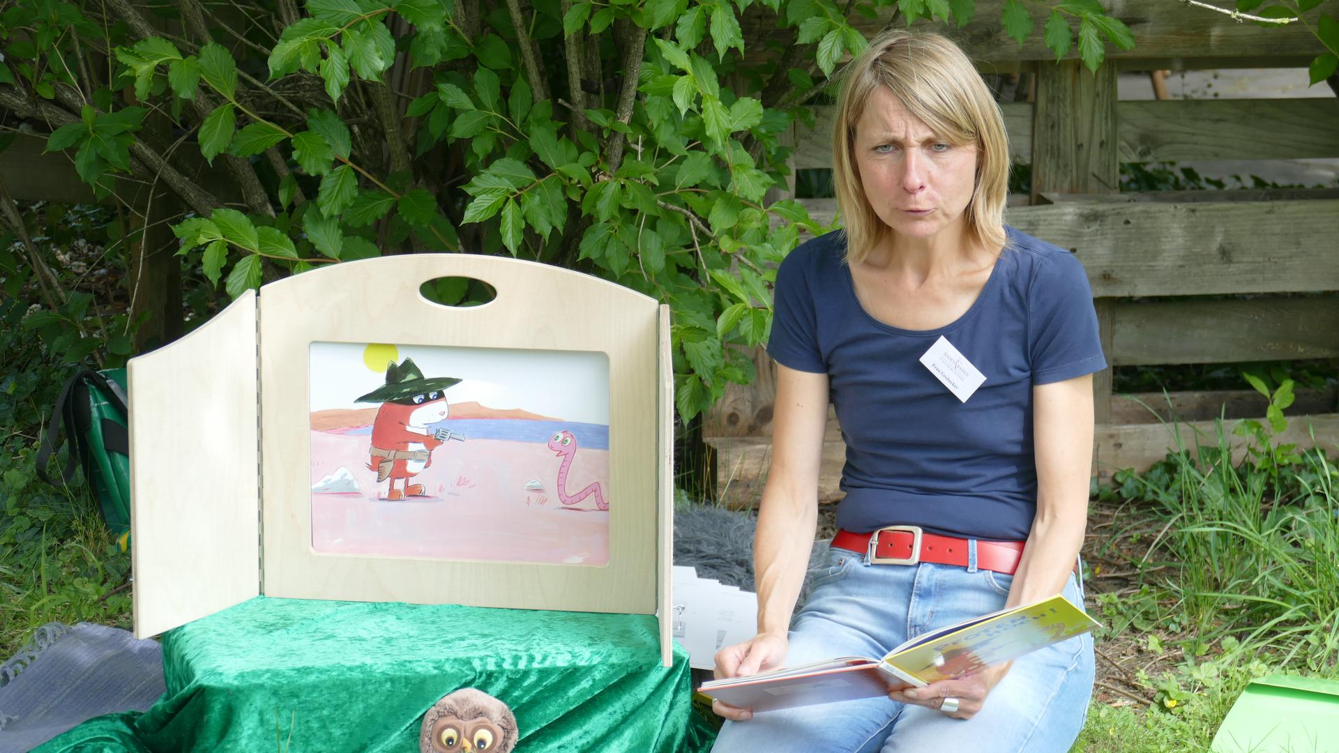 Petra Grobecker liest auf dem Spielplatz beim Festspielhaus