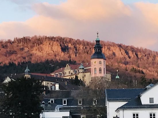 Überragt Baden-Baden: die Stiftskirche. Dahinter im Abendlicht die Battert-Felsen.