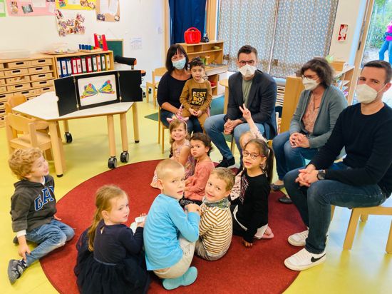 Interessiert: Die Pezzettino-Kinder und Bundestagsabgeordneter Kai Whittaker (Dritter von rechts) lauschen Kita-Sprachförderkraft Natalie Keller (hinten links) beim Erzähltheater. 