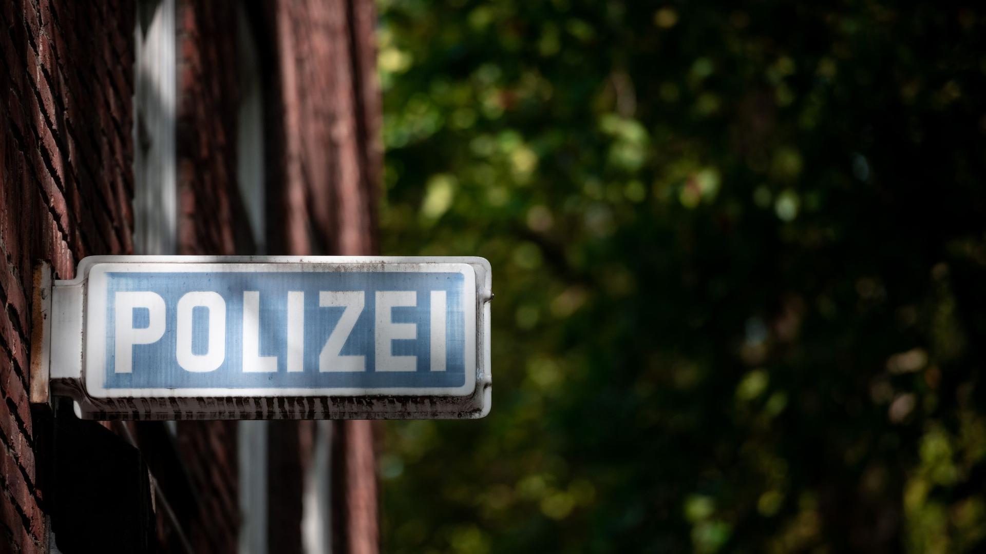 Ein Schild, auf dem „Polizei“ steht, hängt an einer Wache.
