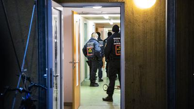 Drogenrazzia in Asylunterkünften – rund 150 Beamte im Einsatz. Polizisten durchsuchen ein Gebäude.
