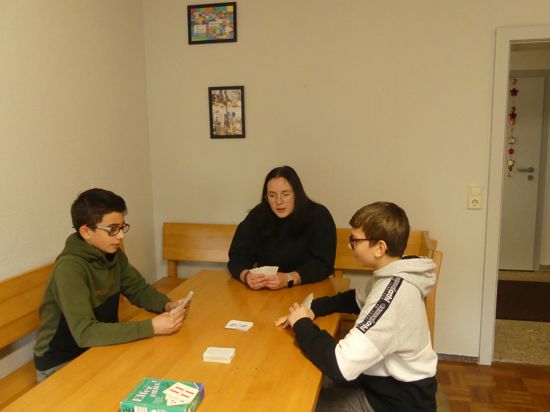 Baran (l.) und Raouls spielen in ihrer Freizeit gerne Karten mit Erzieherin Laura Künnemann