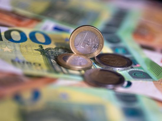 Geldscheine mit dem Wert von 100 und 50 Euro und Münzen liegen auf einem Tisch. 
