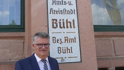 Bühler OB Hubert Schnurr vor einem Mosaik, auf dem „Amts- und Kreisstadt Bühl“ steht.