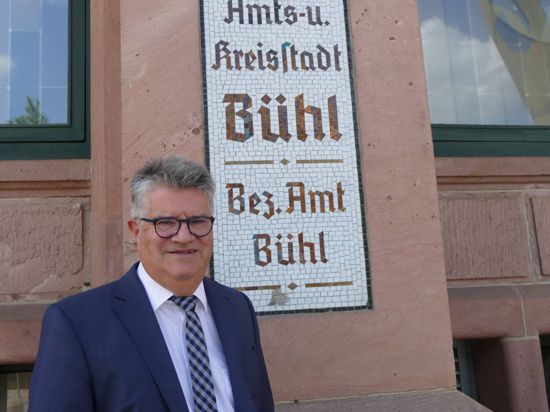Ein Mann steht vor einem Haus mit der Aufschrift Amts- und Kreisstadt Bühl