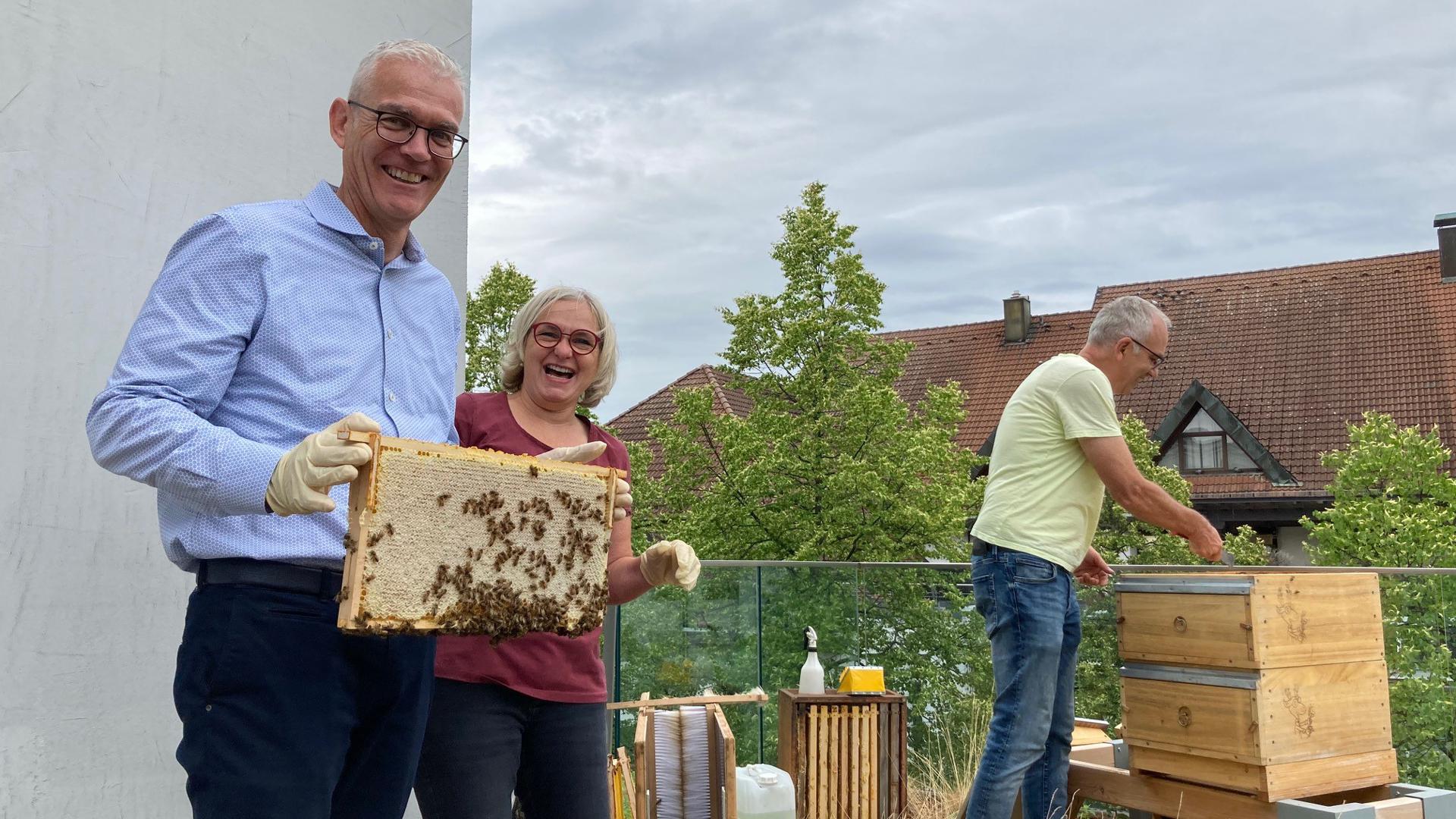 Der Bühler Sparkassen-Chef Frank König zeigt eine Honigwabe mit Bienen, neben ihm stehen Imkerin Sonja Schaufler und Imker-Kollege Adolf Horcher.