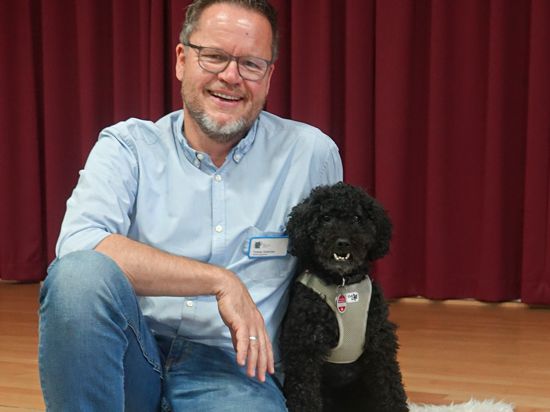 Zwischen Schulhund Nick und Studiendirektor Tobias Hölscher stimmt die Chemie. Der Pudel gehört zu der wachsenden Anzahl von Schulhunden, die ihre Frauchen und Herrchen zur Arbeit als Lehrer begleiten.