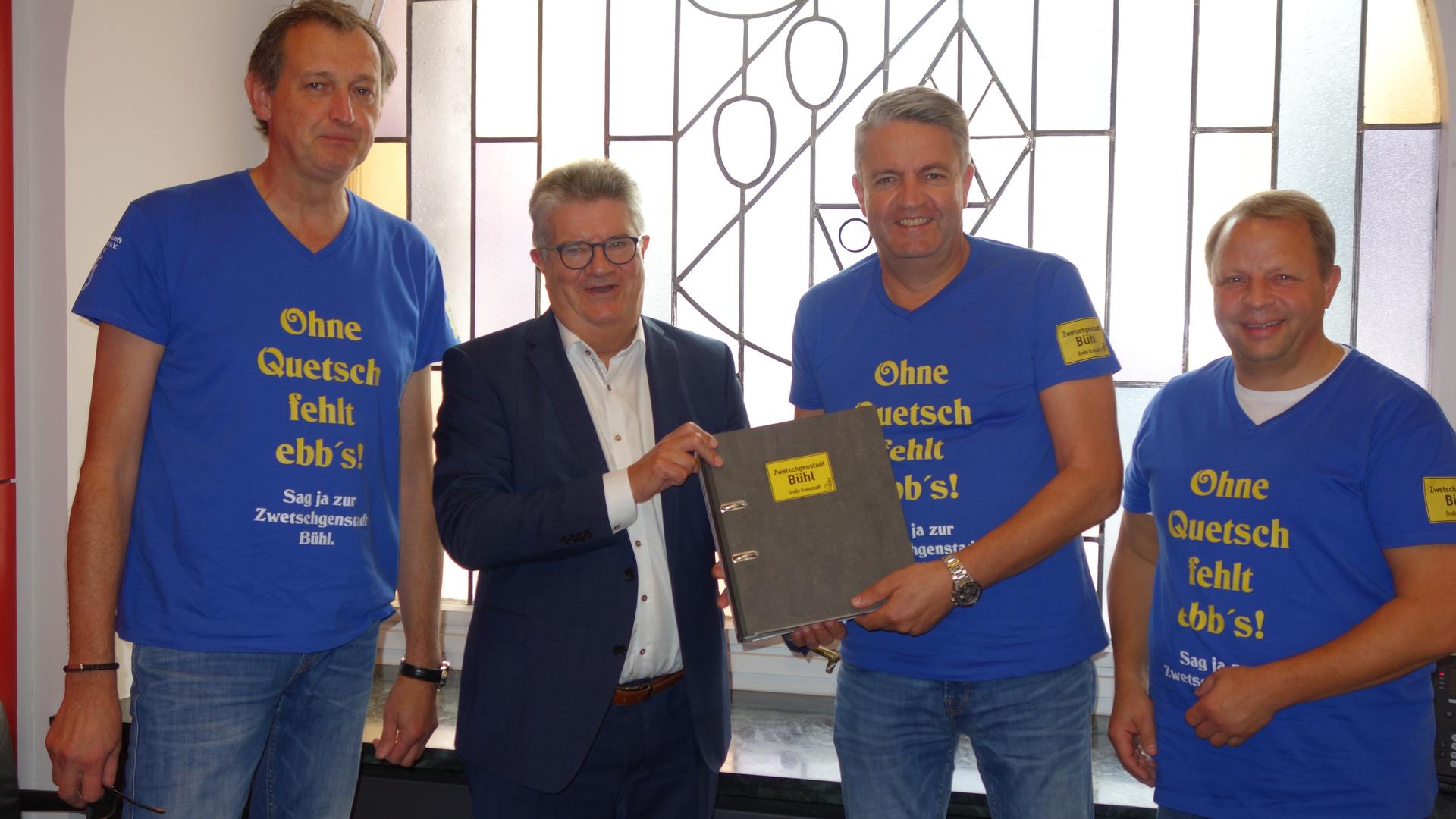 Die Organisatoren pro Zwetschgenstadt Lothar Bäuerle (von links), Michael Vetter und Georg Friedmann überreichen den Ordner mit den Listen an Oberbürgermeister Hubert Schnurr. 