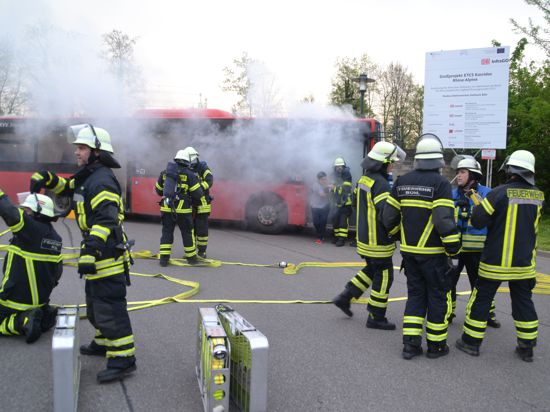 Unter schwerem Atemschutz retten Feuerwehr-Aktive zehn Passagiere aus dem restlos verqualmtem Bus. 