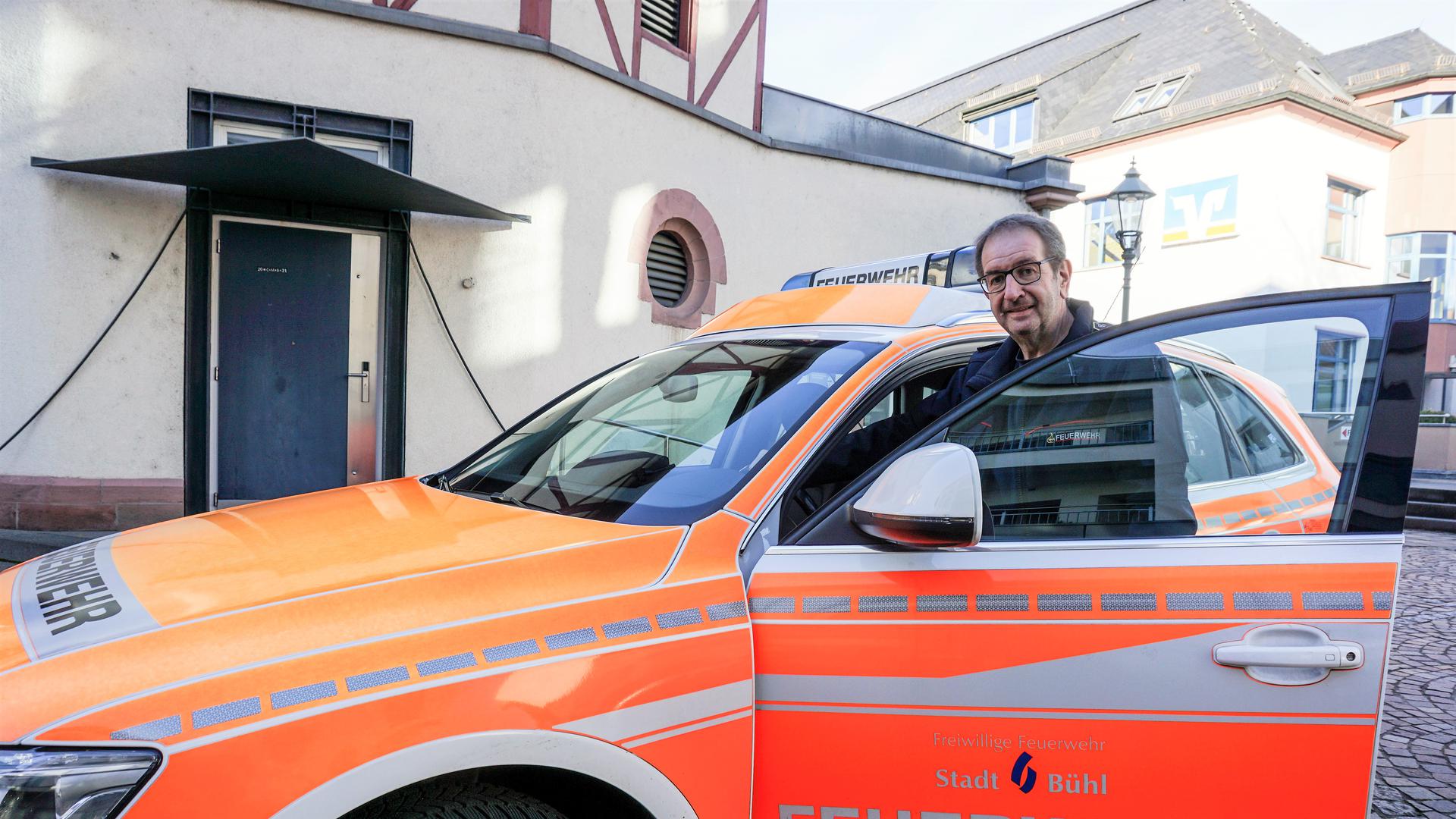Feuerwehrkommandant Günter Dußmann steht vor einem Feuerwehrauto.