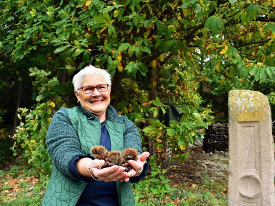 Die Waldmatterin Elfriede Eberle präsentiert vor einer Kastanie in Waldmatt eine Handvoll Keschde