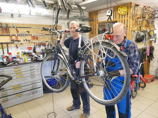 Zwei Männer reparieren ein Fahrrad