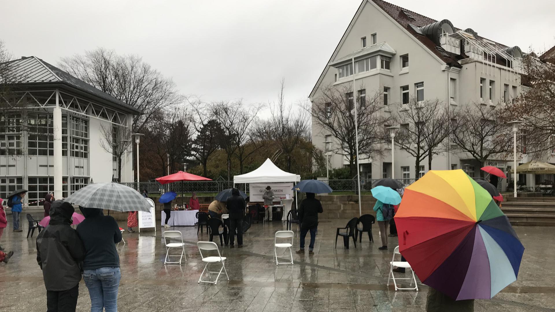 Menschen mit Regenschirmen auf dem Europa-Platz in Bühl