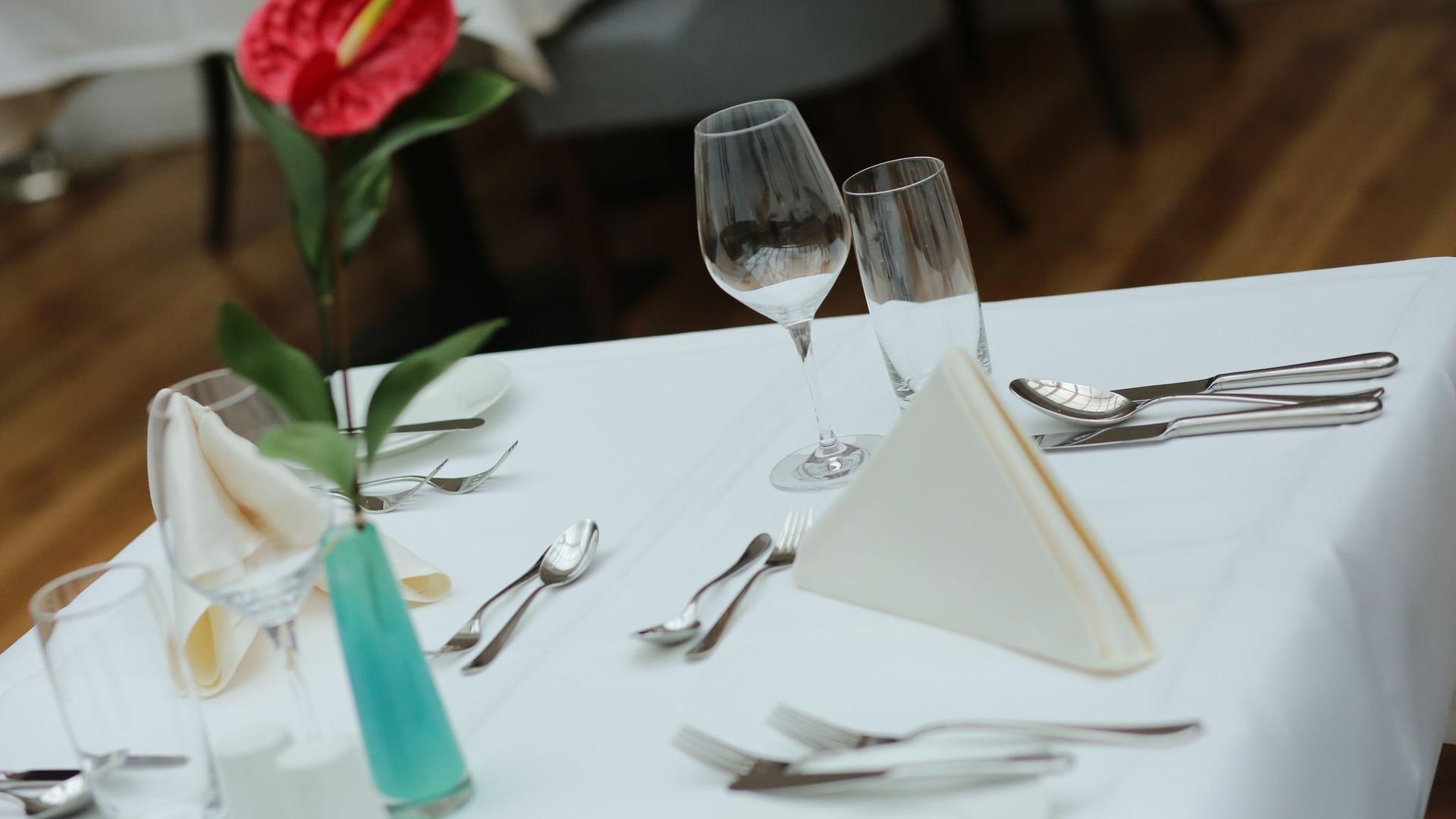 Ein eingedeckter Tisch in einem Restaurant: Viele Gastro-Betriebe klagen einer Umfrage zufolge über ausbleibende Gäste.