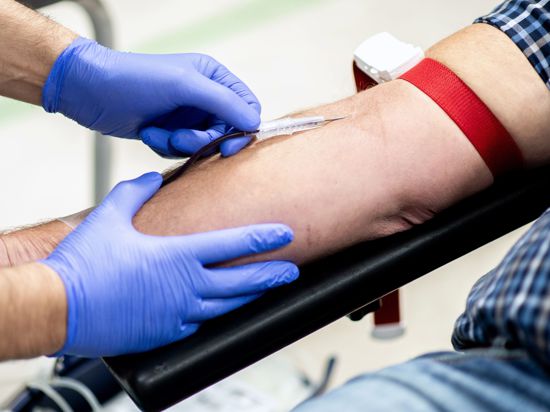 Ein Mitarbeiter vom Blutspendedienst NSTOB des Deutschen Roten Kreuzes fixiert während einer Blutspende die Nadel. Spenderblut ist auch in der Corona-Pandemie wichtig. An zahlreichen Terminen können Menschen auch in Niedersachsen unter strengen Hygieneregeln Blut beim Deutschen Roten Kreuz spenden. +++ dpa-Bildfunk +++