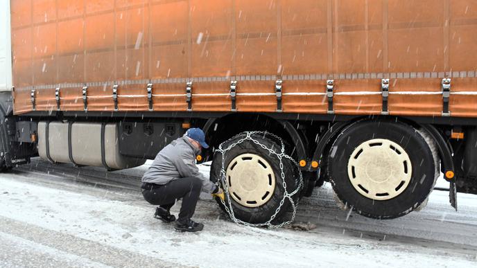 Ein Lkw-Fahrer bereitet sich am Mittwoch mit Schneeketten auf die Weiterfahrt vor.