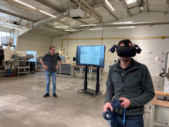 Ein Schaeffler-Mitarbeiter bewegt sich mit Virtual Reality durch das geplante neue Ausbildungszentrum. Der Ausbildungsleiter Sascha Kamm erklärt die bewegten Bilder auf dem Bildschirm. 
