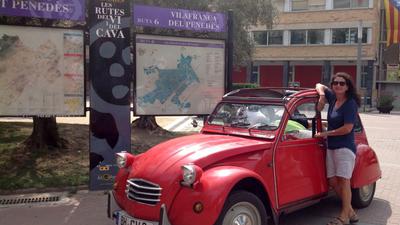 Eine Frau vor einer roten Ente, die vor einem Stadtplan von Villafranca geparkt ist