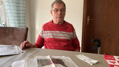 Manfred Klein sitzt am Esstisch hinter einer Zeitung
