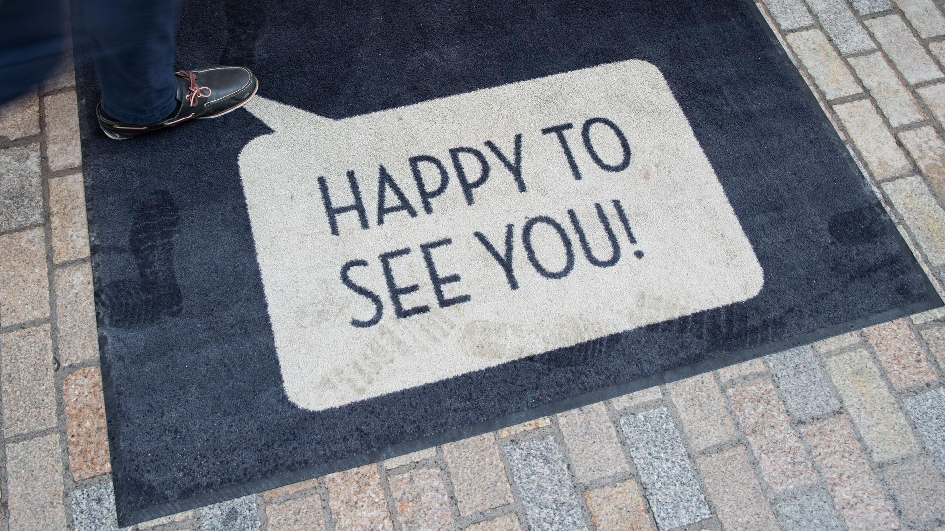 «Happy To See You!» («Schön, Sie zu sehen!») steht auf der Fußmatte eines Ladens in der Fußgängerzone. Mehrere NRW-Kommunen mit niedrigen Corona-Zahlen nutzen die Möglichkeit lokaler Lockerungen bei Handel und Kultur und bieten Einkaufsbummel ohne Anmeldung. +++ dpa-Bildfunk +++