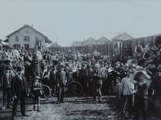 Ein historisches Bild zeigt viele Menschen an einem Bahnhof.