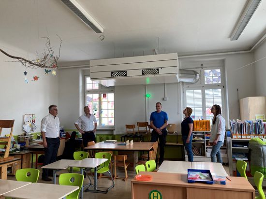 Fünf Personen in einem Klassenraum