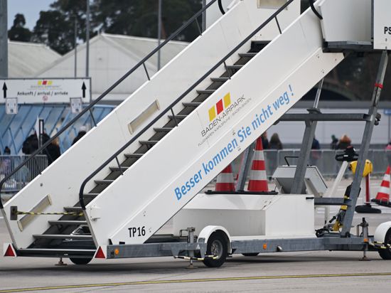 Eine Flugzeuggangway mit der Aufschrift „Besser kommen sie nicht weg“ steht auf dem Flughafen Karlsruhe/Baden-Baden auf dem Rollfeld.