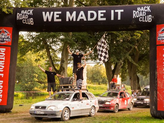 Die Stollhofener „Schlaglochjäger“ feiern auf der Ziellinie der Rallye auf ihrem Auto den dritten Platz.