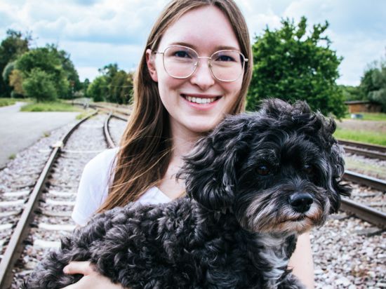 Eileen Eisenack mit Hund Barny auf einem Bahngleis.