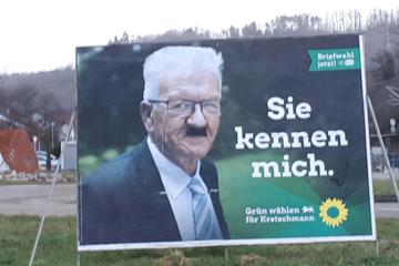 Landtagswahlkampf-Plakat der Grünen, auf dem Winfried Kretschmann mit einem aufgemalten Hitlerbart zu sehen ist.