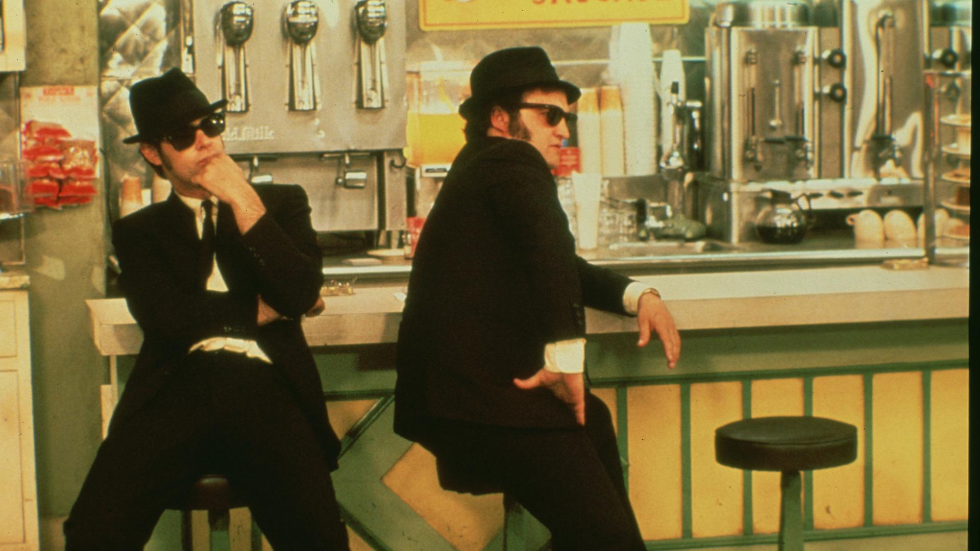 John Belushi (r) als Jake Blues und Dan Aykroyd als Elwood Blues in einer Szene des Films "Blues Brothers - Extended Version" (undatierte Filmszene). 