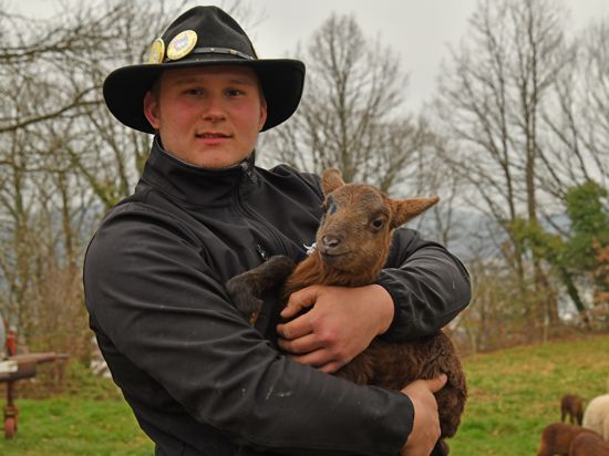 Gerne draußen bei seinen Tieren: Elias Dannenmaier mit einem Lamm der Rasse Coburger Fuchsschaf. Foto: Veronika Gareus-Kugel