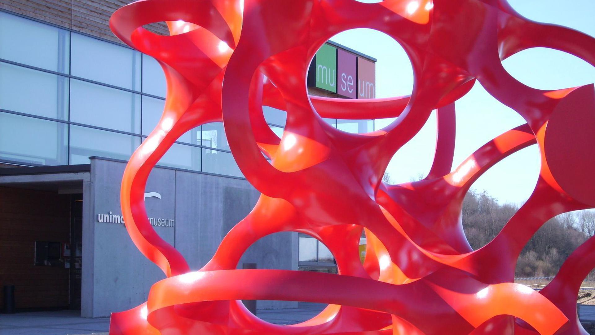 Rote Skulptur aus Metall des Künstlers Eberhard Eckerle vor dem Unimog Museum in Gaggenau