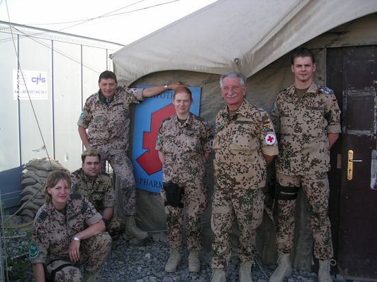 6 Personen in Uniform vor Zelt 
