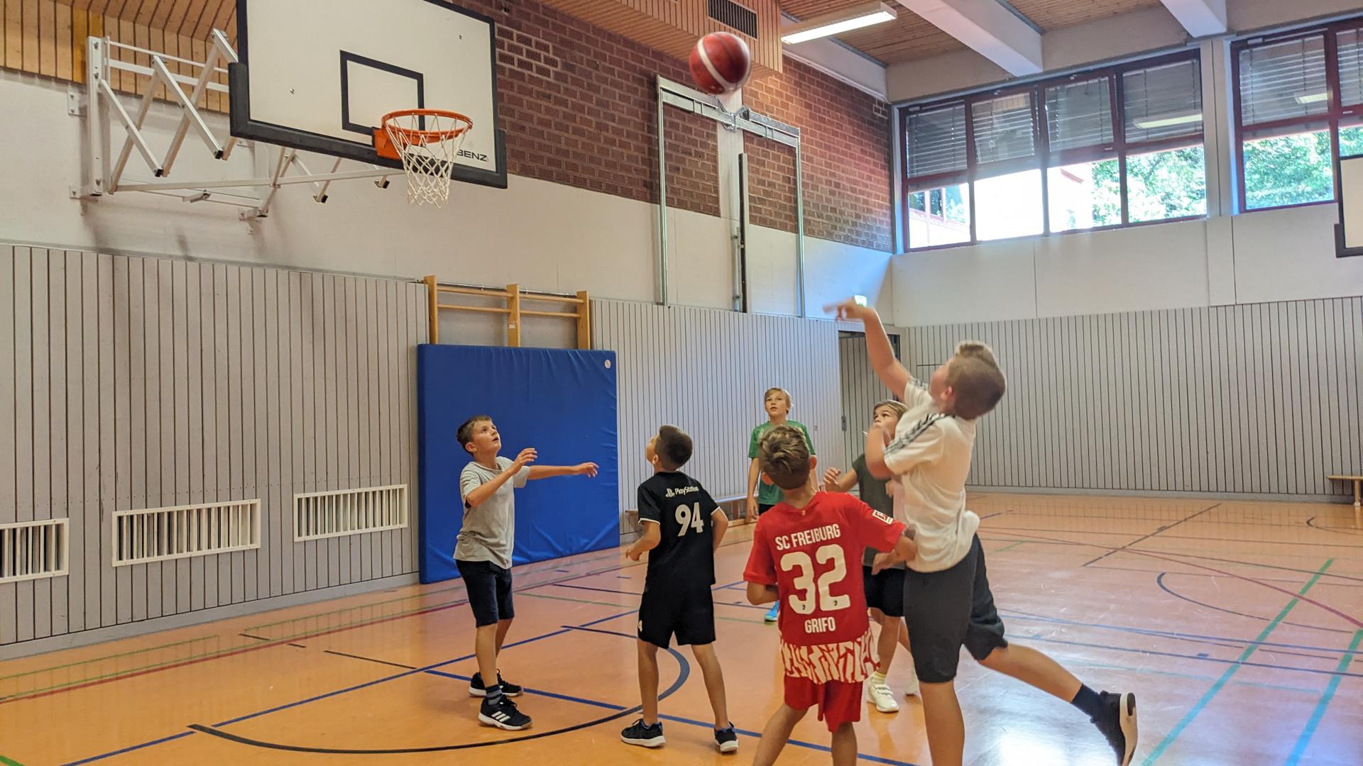 Mehrere Schüler des Gaggenauer Gymnasiums spielen in einer Sporthalle Basketball.