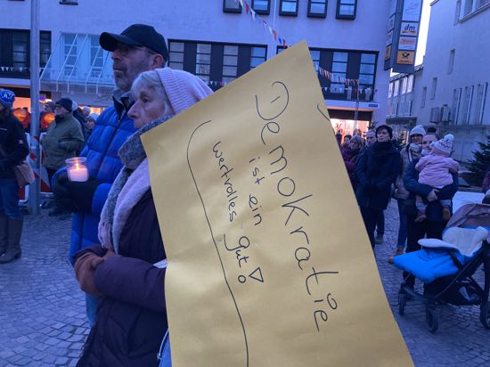 Ein Ehepaar mit Kerze und Protestplakat: Demokratie ist ein wertvolles Gut, steht darauf geschrieben.
