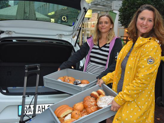Zwei Frauen beim Einladen von Backwaren in ein Auto 