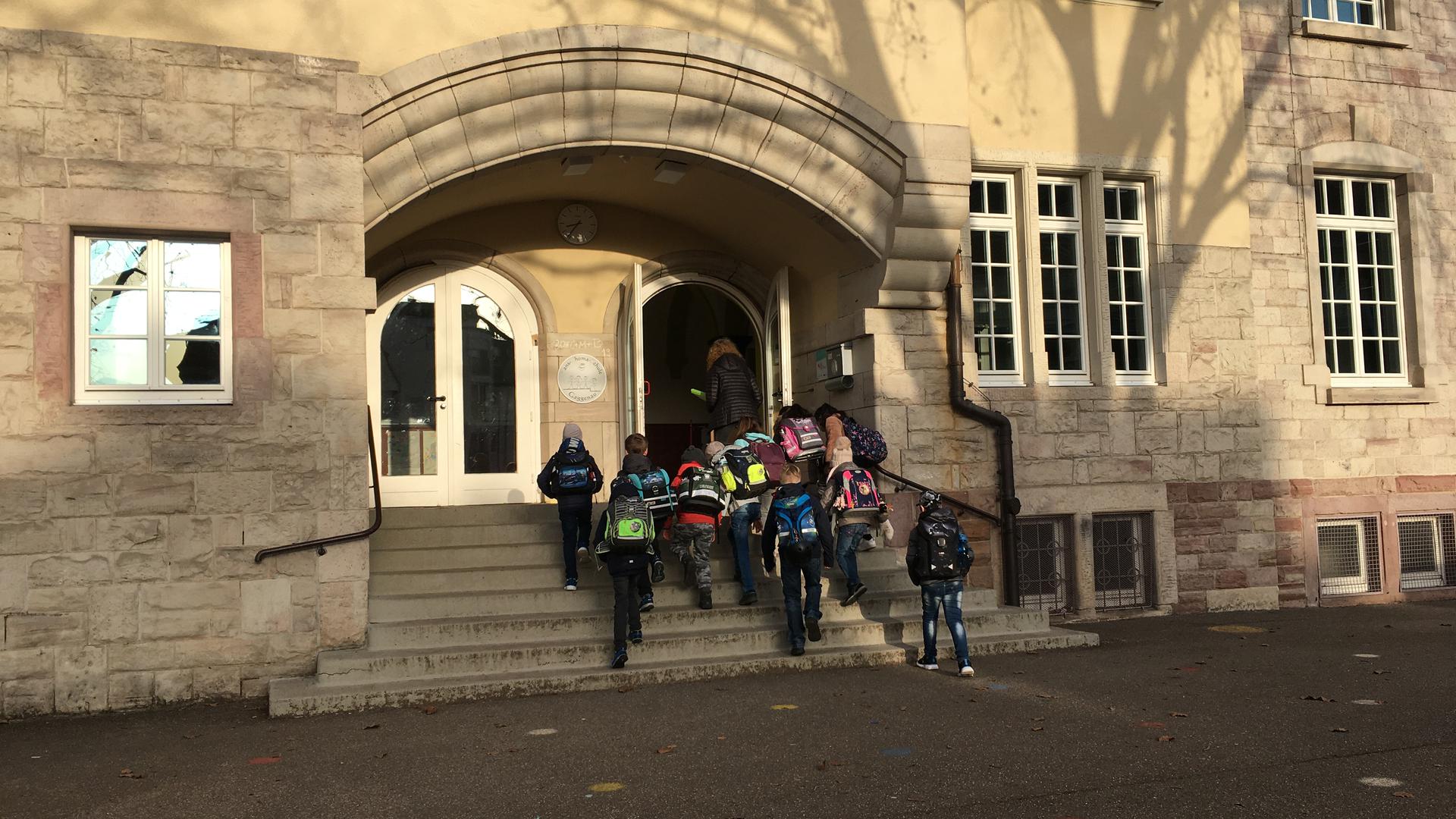 Vor dem Eingang der Hans-Thoma-Schule steht eine Gruppe von Schülern 